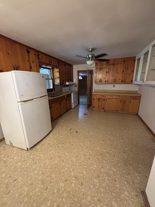 kitchen featuring white appliances, a ceiling fan, light floors, a sink, and brown cabinets