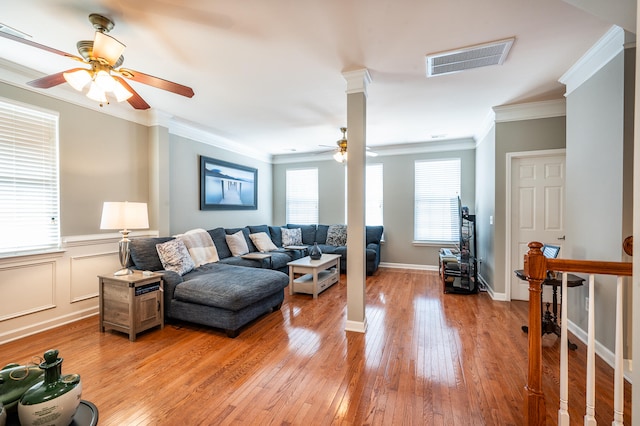 living room with crown molding, light hardwood / wood-style flooring, and ceiling fan