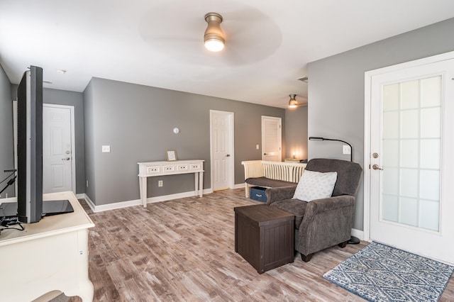 living room with ceiling fan and light hardwood / wood-style floors