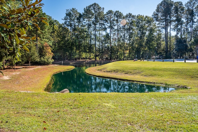 view of home's community featuring a lawn and a water view