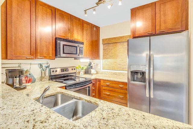 4403 Sea Forest Dr, Kiawah Island, SC 29455 - kitchen featuring stainless steel appliances, a sink, light stone countertops, and brown cabinetry
