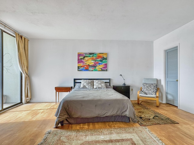 bedroom with multiple windows and wood finished floors