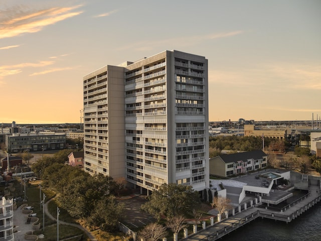 view of building exterior featuring a water view and a city view