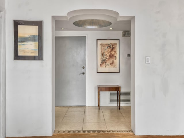 hall featuring light tile patterned floors and visible vents