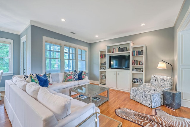 living room with light hardwood / wood-style flooring and crown molding