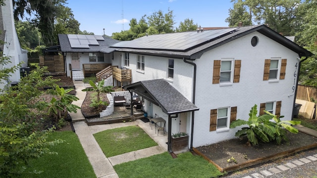 4619 Jenkins Ave Unit 1-4, North Charleston, SC 29405 - view of front of home with roof mounted solar panels, a fenced backyard, brick siding, and roof with shingles