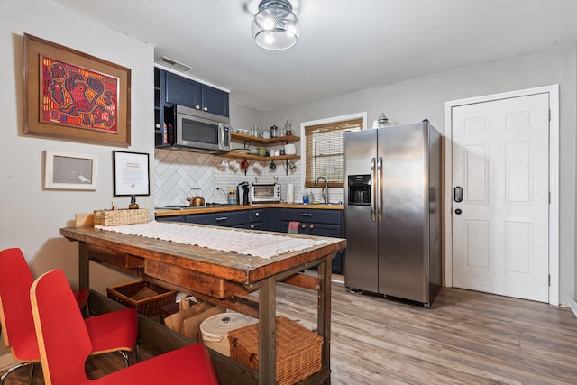 4619 Jenkins Ave Unit 1-4, North Charleston, SC 29405 - kitchen with stainless steel appliances, open shelves, light wood finished floors, blue cabinets, and tasteful backsplash
