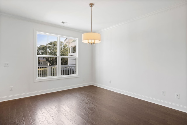 spare room featuring dark wood-type flooring and crown molding