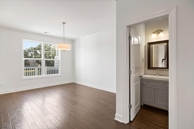 unfurnished dining area with crown molding, dark hardwood / wood-style flooring, and sink