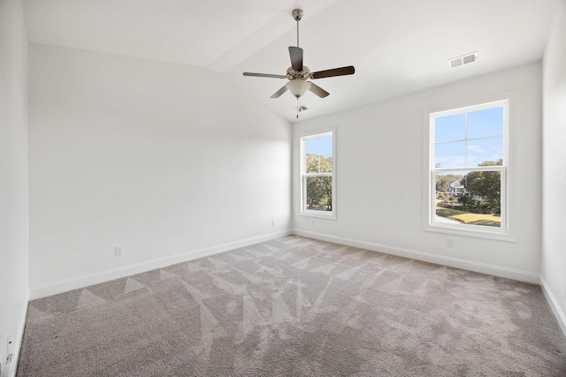 empty room with ceiling fan, lofted ceiling, and carpet