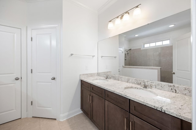 bathroom featuring a tile shower, vanity, crown molding, and tile patterned floors