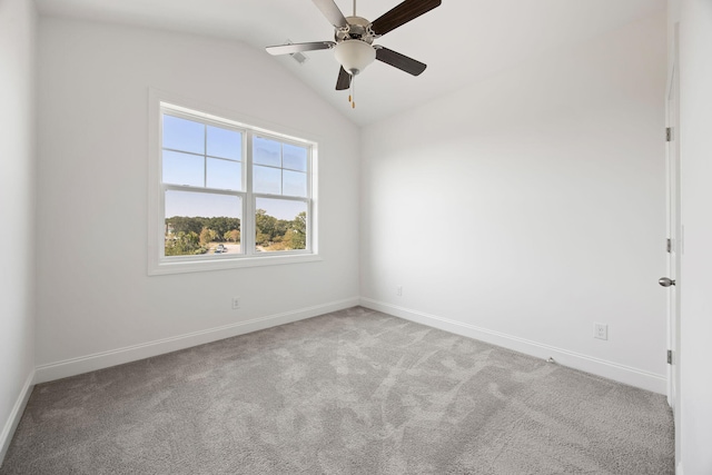 carpeted spare room featuring lofted ceiling and ceiling fan