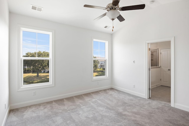 empty room with ceiling fan, lofted ceiling, and light carpet