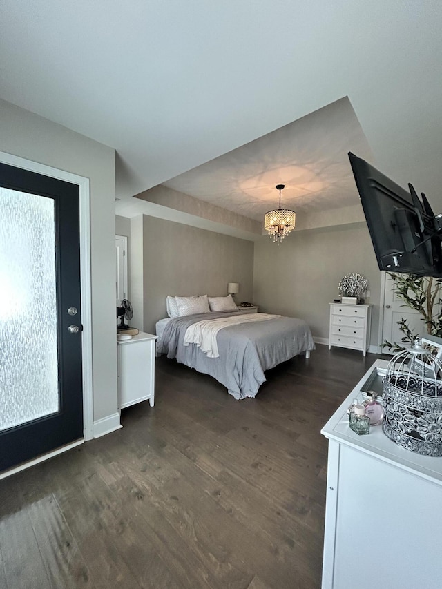 bedroom with dark wood-style flooring, baseboards, and a chandelier