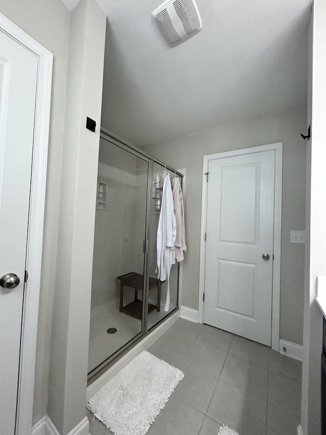 full bathroom featuring a shower stall, tile patterned floors, baseboards, and vanity