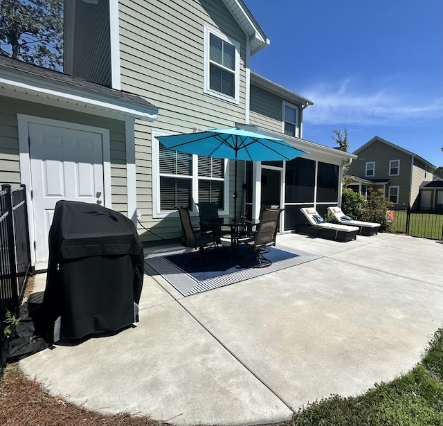 view of patio / terrace featuring a sunroom, fence, and a grill