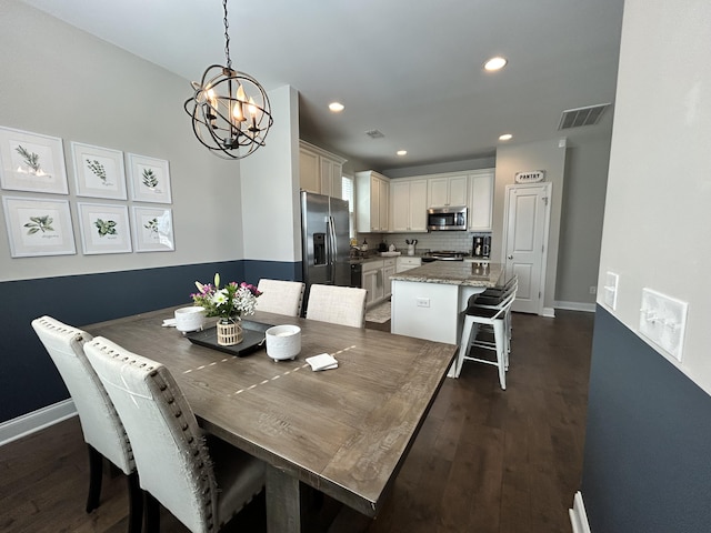 dining room with a chandelier, dark wood-style floors, recessed lighting, and baseboards