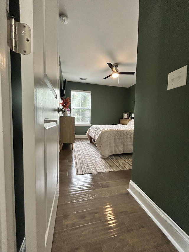 bedroom with baseboards, hardwood / wood-style flooring, and ceiling fan