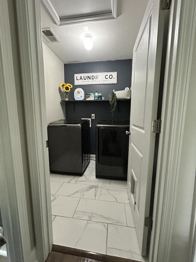 clothes washing area featuring washer and clothes dryer and light marble finish floors