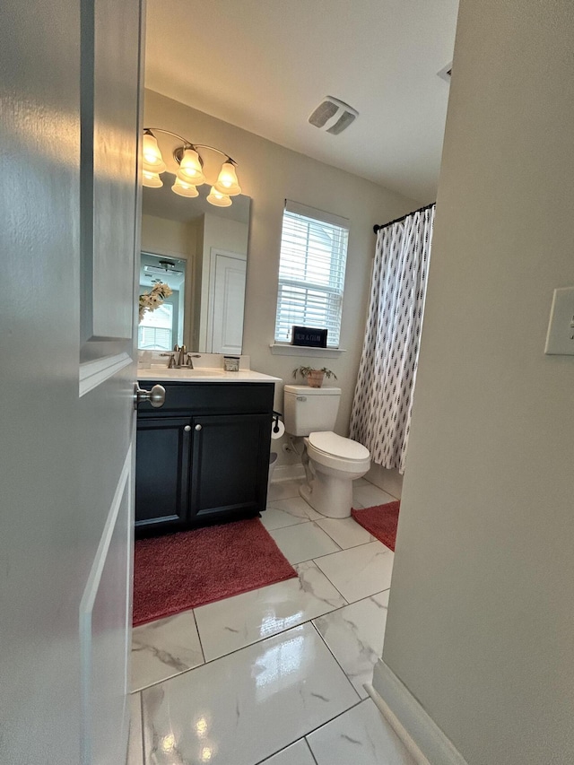 full bathroom with toilet, marble finish floors, vanity, and curtained shower