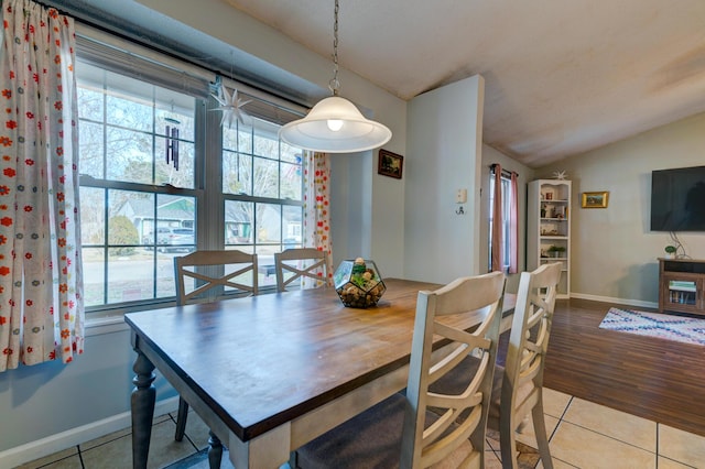 tiled dining space featuring lofted ceiling