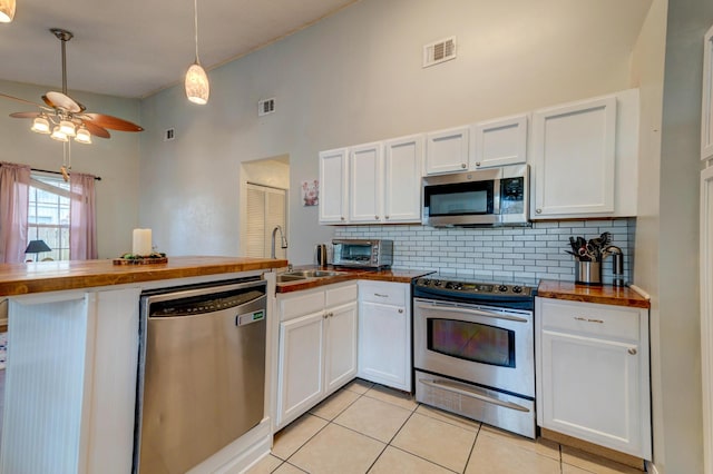 kitchen featuring wood counters, sink, white cabinetry, appliances with stainless steel finishes, and kitchen peninsula