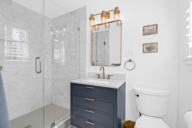 bathroom with vanity, toilet, and a shower with door