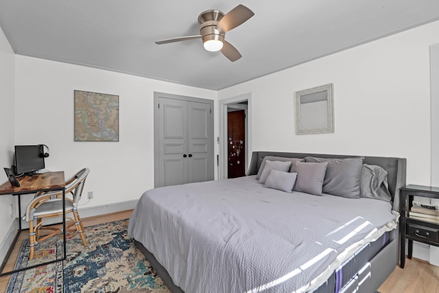 bedroom with hardwood / wood-style floors, ceiling fan, and a closet