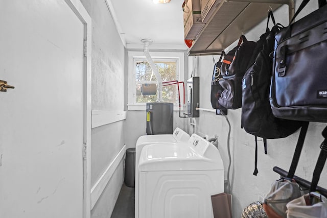 clothes washing area featuring electric panel, washing machine and dryer, and water heater