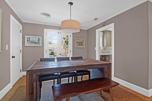 dining space with ornamental molding and hardwood / wood-style floors