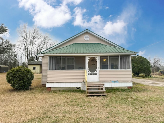 view of front of home featuring a sunroom and a front lawn