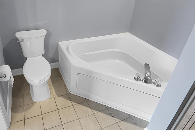 bathroom with toilet, tile patterned flooring, and a washtub