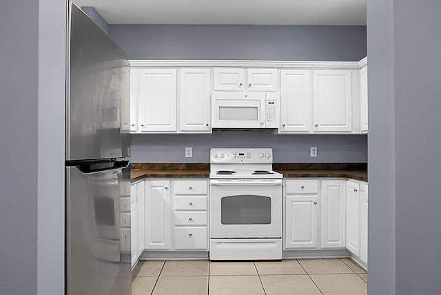 kitchen with light tile patterned flooring, white appliances, and white cabinets