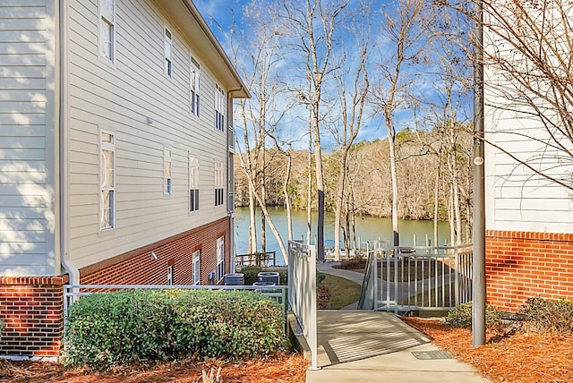 view of property exterior with a water view and central air condition unit