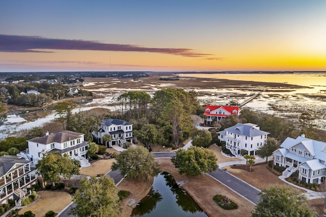 aerial view at dusk with a residential view and a water view