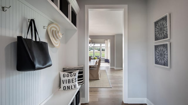 mudroom with a notable chandelier, wood finished floors, and baseboards