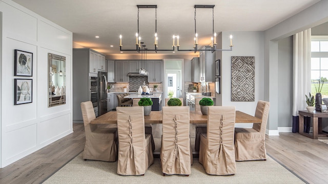 dining room with baseboards, wood finished floors, and an inviting chandelier