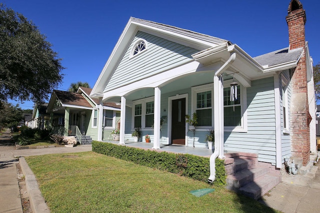 view of front of house with a porch and a front lawn