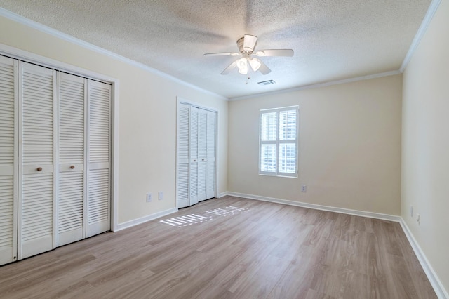 6275 Rolling Fork Rd Unit 401, North Charleston, SC 29406 - unfurnished bedroom featuring light wood-style flooring, ornamental molding, multiple closets, a textured ceiling, and ceiling fan