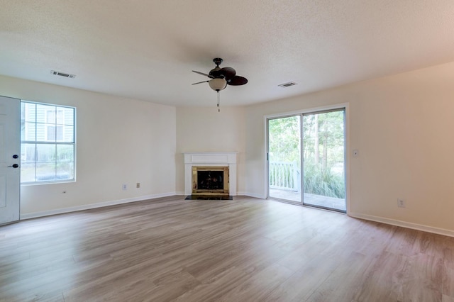 6275 Rolling Fork Rd Unit 401, North Charleston, SC 29406 - unfurnished living room with plenty of natural light, a ceiling fan, light wood-style floors, and a textured ceiling