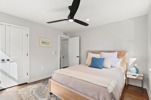 bedroom featuring a closet, dark hardwood / wood-style floors, and ceiling fan