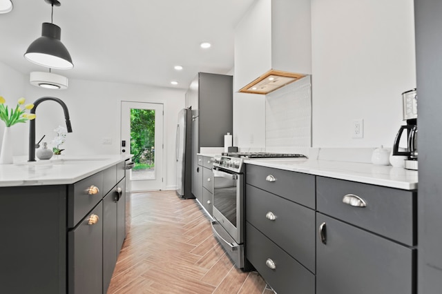 kitchen with premium range hood, light parquet floors, light stone countertops, appliances with stainless steel finishes, and decorative light fixtures