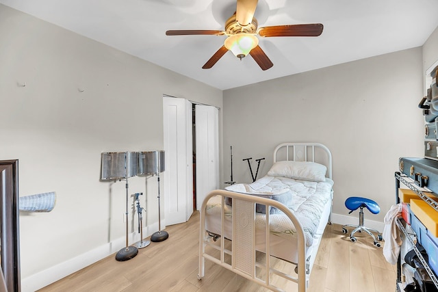 bedroom featuring baseboards, ceiling fan, a closet, and light wood finished floors