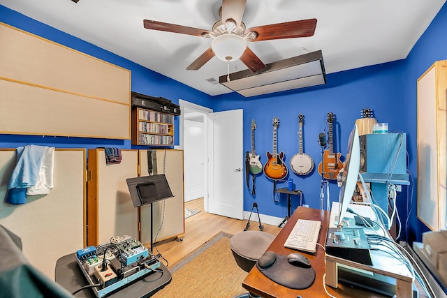 workout area with a ceiling fan, baseboards, visible vents, and wood finished floors