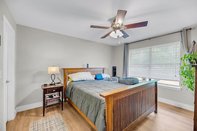 bedroom with baseboards, a ceiling fan, and light wood-type flooring