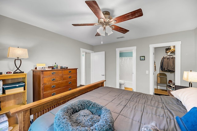 bedroom with ensuite bath, a ceiling fan, a spacious closet, visible vents, and a closet