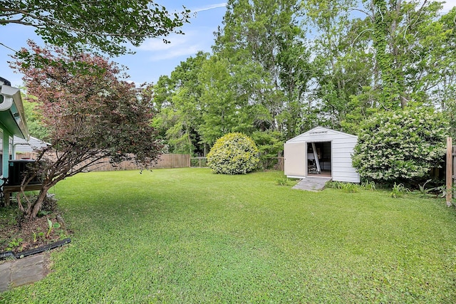 view of yard featuring an outdoor structure, a fenced backyard, and a shed
