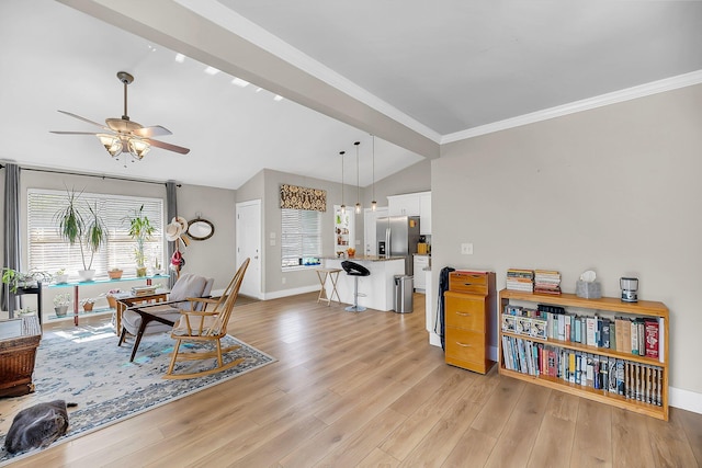 living room with crown molding, ceiling fan, light wood-style floors, baseboards, and lofted ceiling