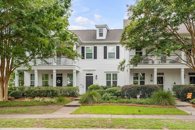 view of front of home with a shingled roof and a balcony