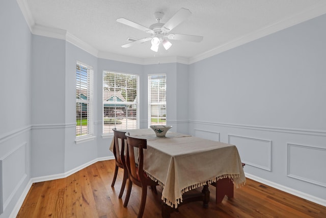 1394 Center Lake Dr, Mount Pleasant, SC 29464 - dining area featuring wood finished floors, a ceiling fan, wainscoting, crown molding, and a decorative wall